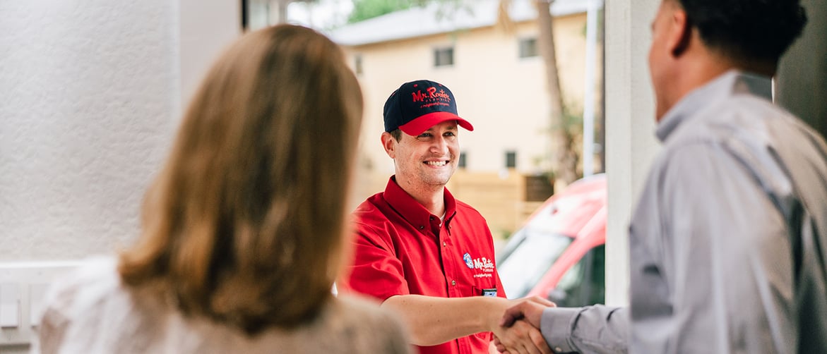 Featured image: Mr. Rooter franchise technician assisting a customer. - 5 Benefits of Investing in a Plumbing Franchise