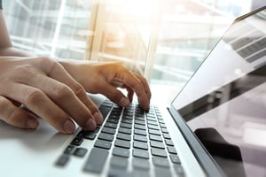 Featured image: Man typing on keyboard - Great Tech Tools for Franchise Business Owners