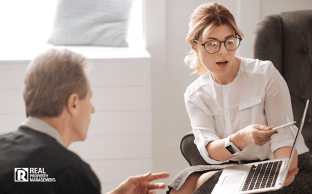 Woman pointing to laptop screen in discussion about online compliance Woman pointing to laptop screen in discussion about online compliance