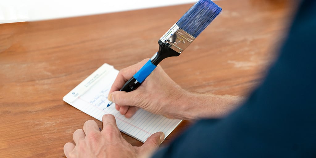 person writing with a paint brush pen