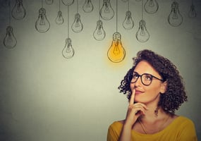 Woman with light bulbs above head. - Recession-Resilient Business Ideas