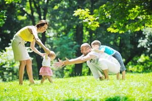 Featured image: Family playing outdoors on grass. - Green Business Ideas: Eco-Friendly Pest Control with Mosquito Joe®